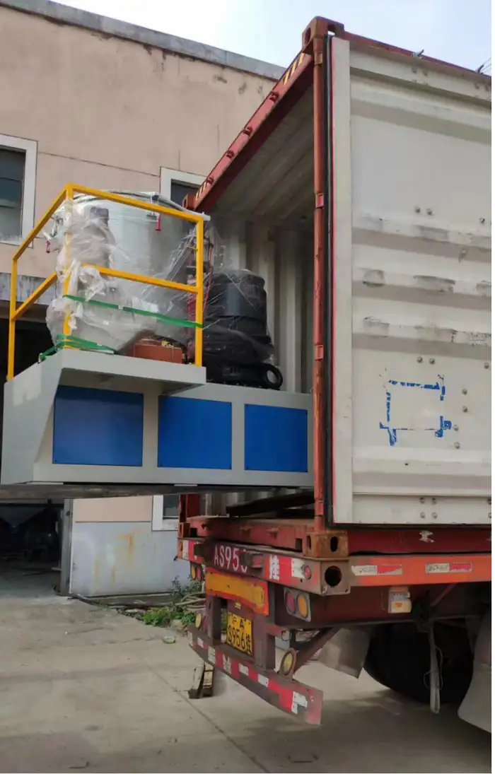 Industrial machinery on a loading platform beside a shipping container